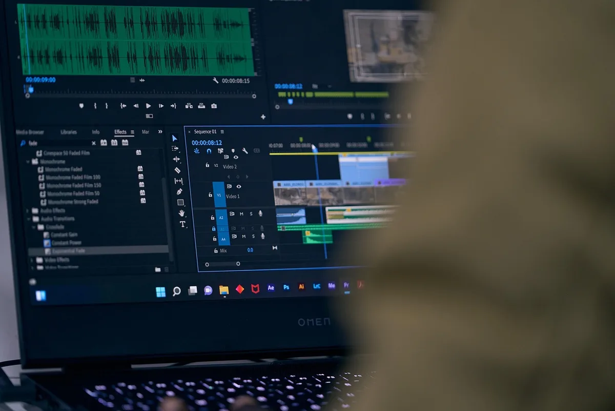 A video editor's computer screen showing a timeline with multiple clips and audio tracks in Premiere Pro.